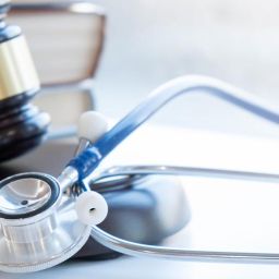 image of medical malpractice items such as stethoscope and court mallet.