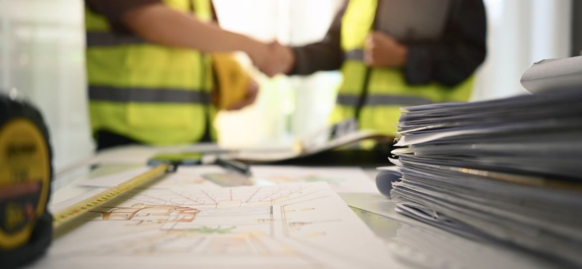 image of construction workers shaking hands over proper documentation in construction projects