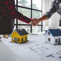 image of two people shaking hands over real estate development agreements