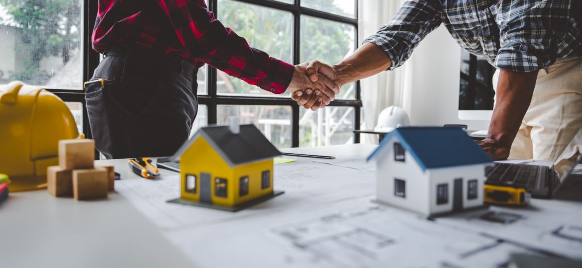 image of two people shaking hands over real estate development agreements