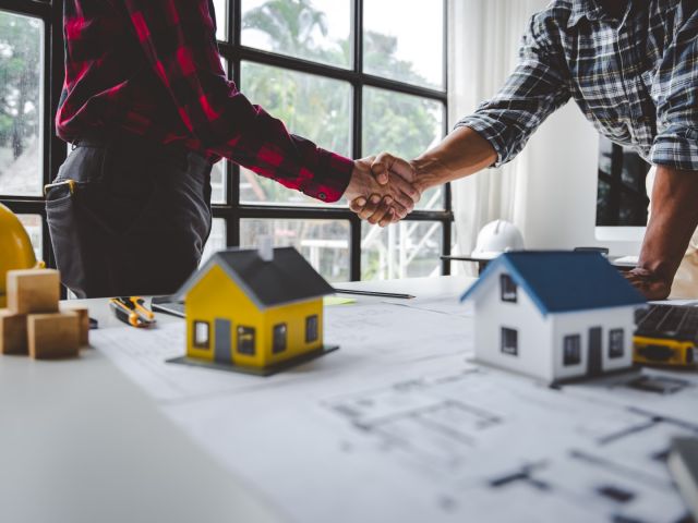 image of two people shaking hands over real estate development agreements